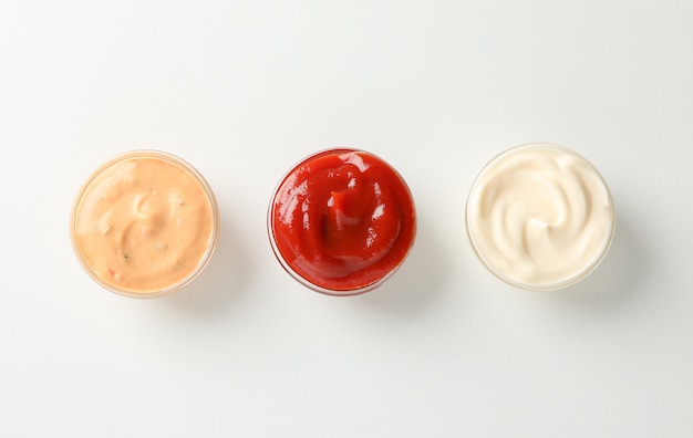 Photo set of tasty sauces on white background, space for text. top view