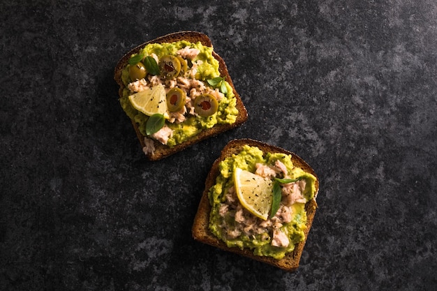 Set Tasty tuna toast Italian bruschetta sandwiches with canned tuna avocado olives Delicious breakfast or snack Top view