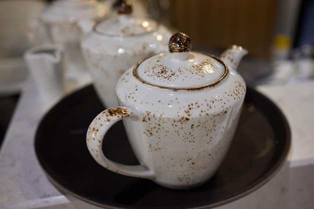 A set of teapots with small cups that are unique and classic