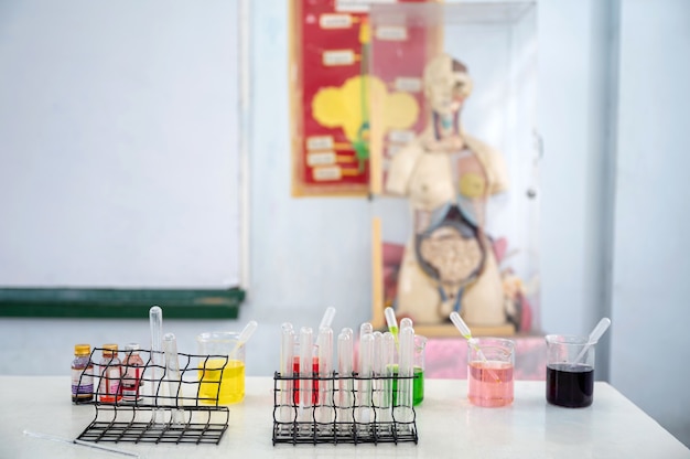 과학 수업의 실험 실험실에서 책상에 테스트 튜브와 다채로운 비커 및 실험 물질 세트