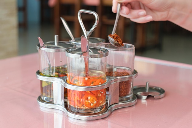 Set Thaise kruiden in glazen potten op een tafel in een café