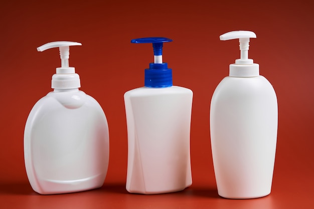 Set of three clean white plastic bottles with soap dispenser