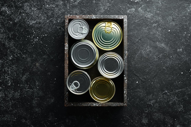 Set of tin cans with food in wooden box Top view Free space for your text