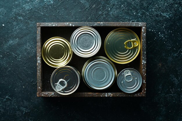 Set of tin cans with food in wooden box Top view Free space for your text