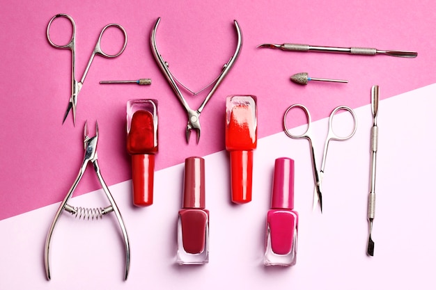 A set of tools for manicure and nail polish on a pink background with a place for text