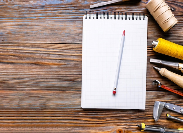 Photo set of tools notebook pencil for shoemaker on a wooden background