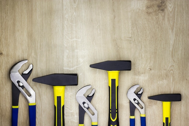 Set tools op een houten tafel. Hamers en moersleutels. Sanitair gereedschap.