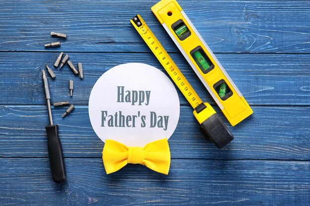 Set of tools with greeting card on wooden background Father's Day concept
