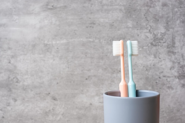 Set of Toothbrushes in cup on wall background at bathroom. World oral health day and free dental day concept