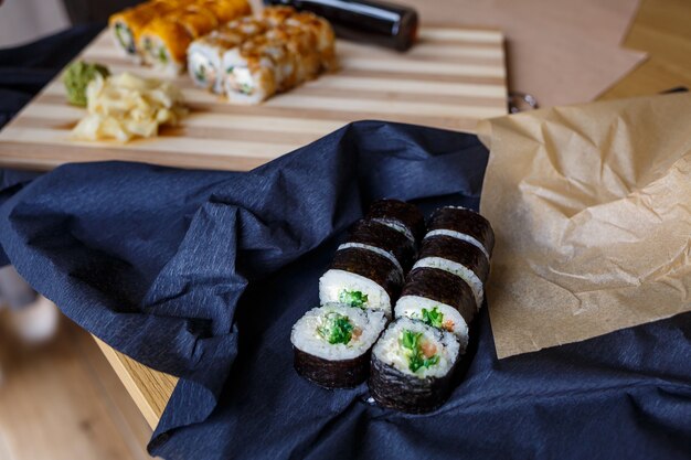 Set of traditional Japanese dishes. Sushi rolls, nigiri, raw salmon, rice, cream cheese, avocado, pickled ginger.