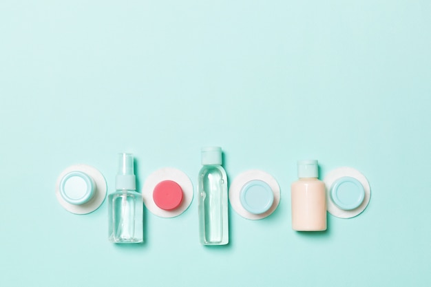 Photo set of travel size cosmetic bottles on blue background. flat lay of cream jars