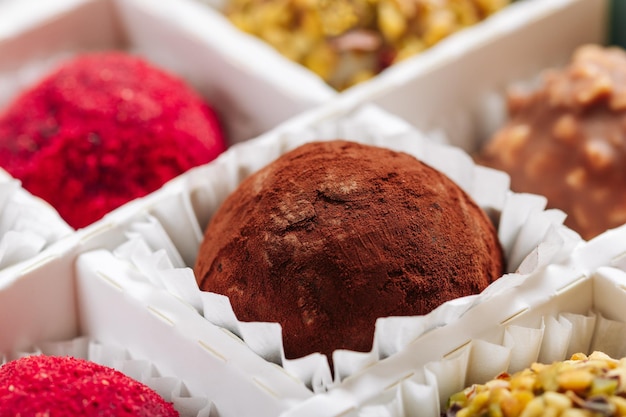 A set of truffle sweets with different fillings in a box closeup