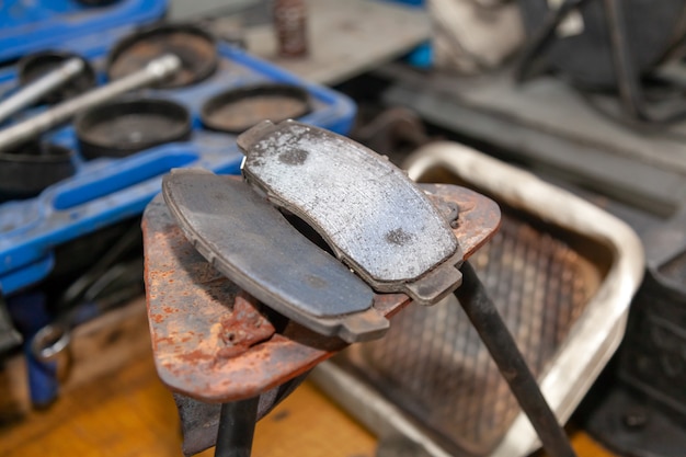 set of two old automobile brake pads on a garage.