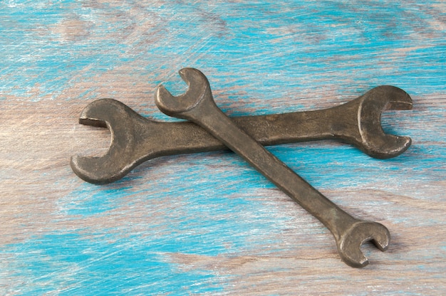 Set of two vintage bronze wrench on shabby blue wooden background. Copy space for text.