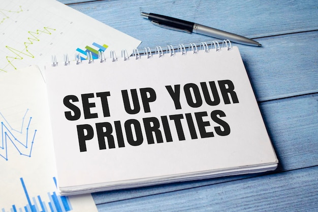 SET UP YOUR PRIORITIES text on notepad with pen business