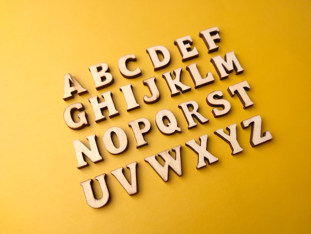 Set van 26 houten letters geheel alfabet op gele achtergrond