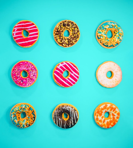 Set van 9 verschillende kleurrijke donuts geïsoleerd op blauwe achtergrond Minimal food concept