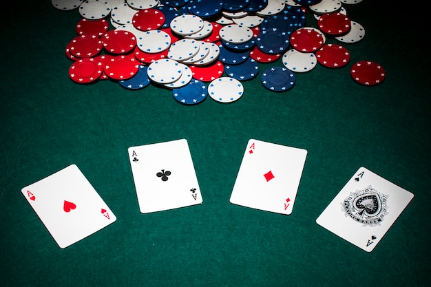 Foto set van azen speelkaart en casino chips op groene pokertafel