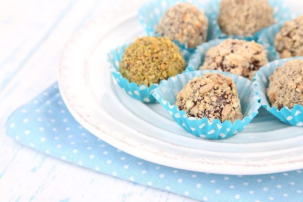 Set van chocolade snoepjes, op plaat, op houten achtergrond