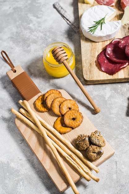 Set van crackers op houten snijplank, honing.