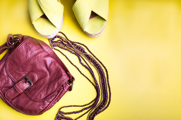 Set van dingen van de vrouw accessoires voor het zomerseizoen. Bruine tas gele platform sandalen, ketting. Plat leggen.