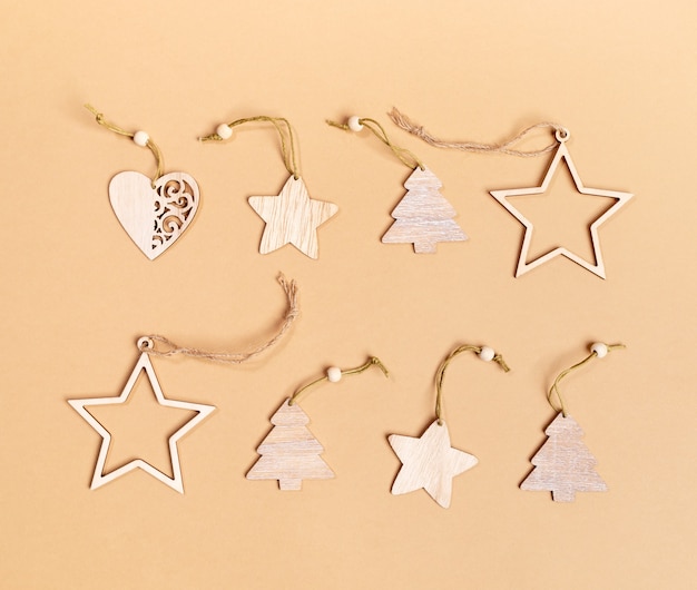 Set van feestelijke kerstversiering - houten sterren, kerstbomen, harten op beige achtergrond. Bovenaanzicht. Detailopname. Horizontale oriëntatie.