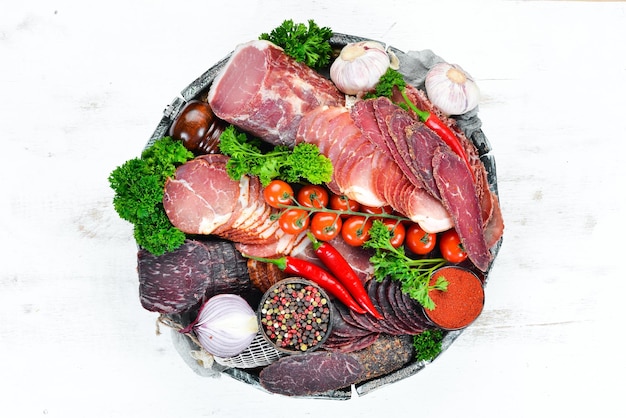Set van gerookt en gedroogd vlees Ham schokkerig gezouten biltong vlees specerijen en kruiden Bovenaanzicht Vrije ruimte voor uw tekst