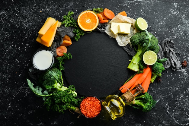 Set van groenten, fruit en voedsel op een zwarte stenen achtergrond Voedingsmiddelen zijn rijk aan vitamine A Bovenaanzicht Vrije ruimte voor uw tekst