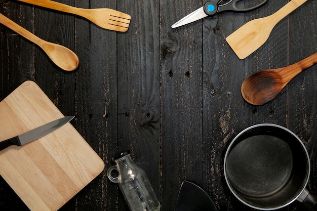 Set van keukengerei op de zwarte houten achtergrond