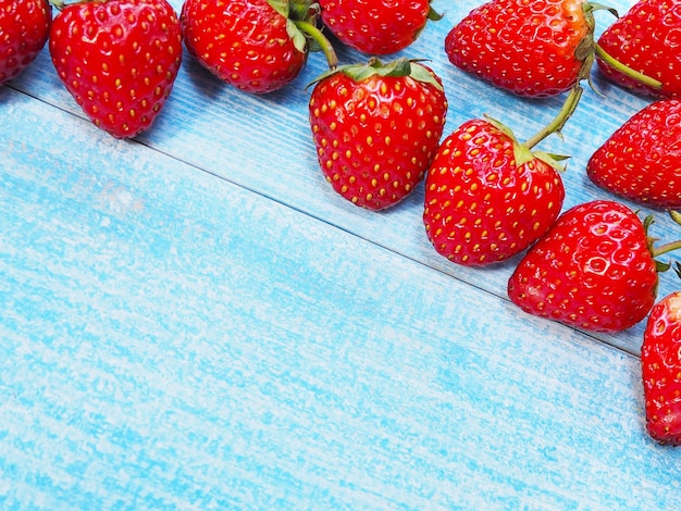 Set van rode aardbeien op blauwe houten achtergrond. Sappig fruit.