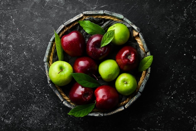 Set van rode en groene appels op een dienblad. Rustieke stijl. Op een zwarte stenen achtergrond.