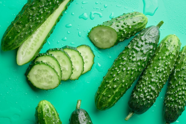 Set van verse hele en gesneden komkommers geïsoleerd op groen.