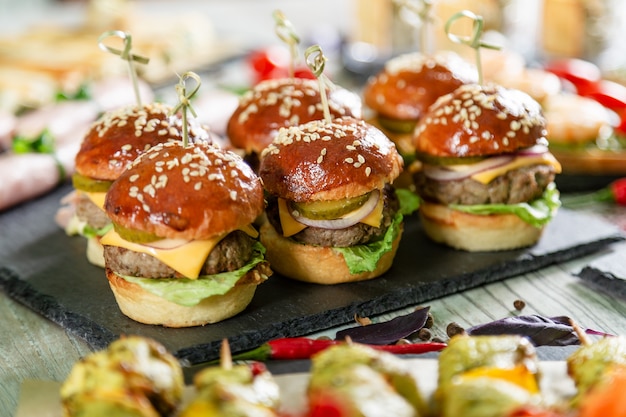 Set van vlees hamburgers op zwarte bord op houten tafel