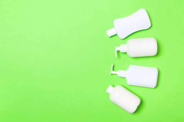Set van witte cosmetische containers geïsoleerd op groen, bovenaanzicht met copyspace. groep plastic bodycare flessencontainers met lege ruimte