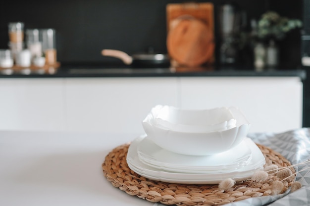 Set van witte minimalistische gerechten op een tafel tegen de achtergrond van een keuken
