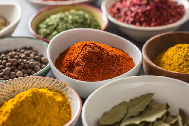 Set of variety aromatic spices and herbs in bowls.