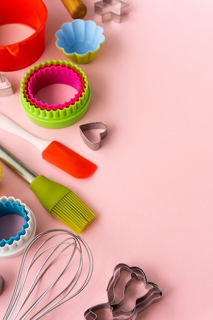 Photo set of various baking utensils on pink surface.