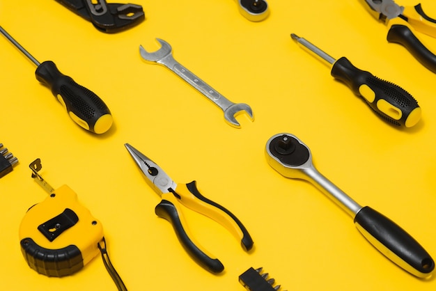 Photo set of various construction tools. tools for home repair. work at a construction site. on a yellow background. flatly. flatlay.