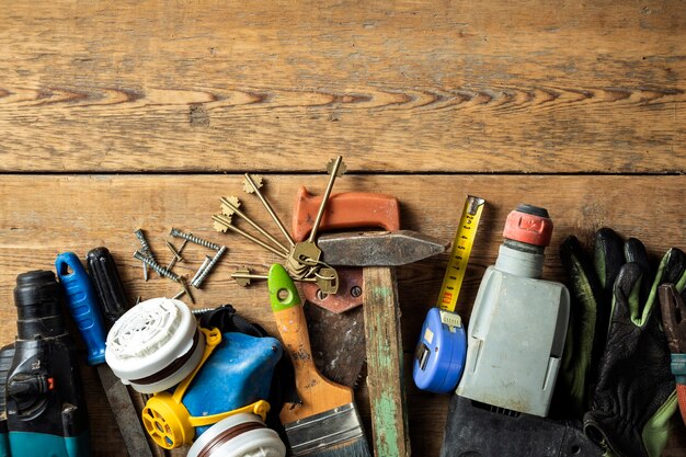 Set of various old handmade tools on wooden background top view