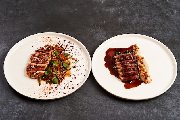 Set of various plates of food on a gray table background with copy space