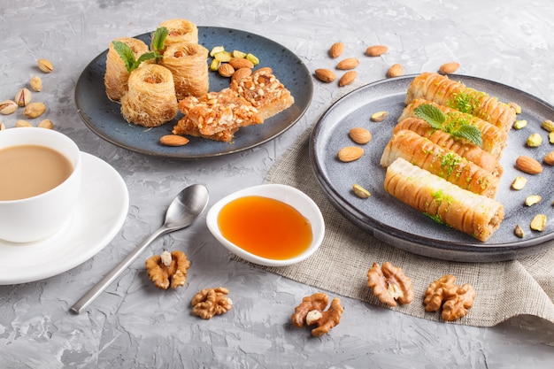 Set of various traditional arabic sweets: baklava, kunafa, basbus in  ceramic plates top view.