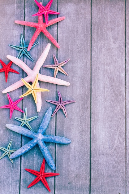 Set veelkleurige zeesterren op een houten bord als rand