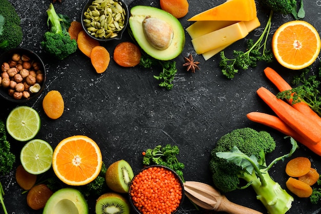 Set of vegetables fruits and food on a black stone background Foods are rich in vitamin A Top view Free space for your text