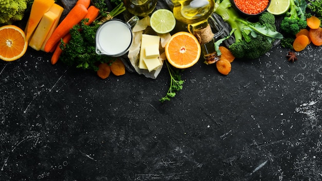 Set of vegetables fruits and food on a black stone background Foods are rich in vitamin A Top view Free space for your text