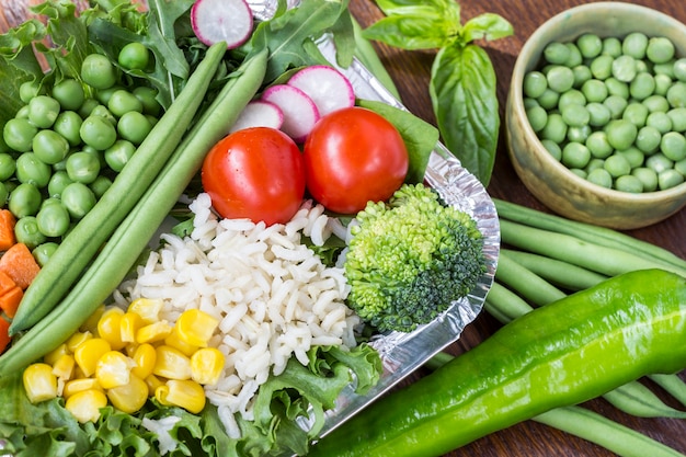 健康的な食事のためのご飯と野菜のセット：トウモロコシ、エンドウ豆、アスパラガス、ニンジン、ブロッコリー、レタス