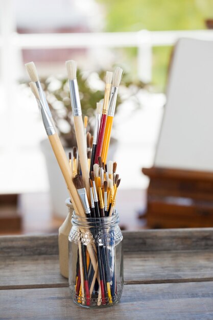 Set verfborstels in een pot op houten tafel