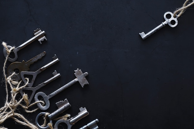 Set of vintage keys for a lock. Retro keys on a dark stone background. The concept of choosing the path to achieve the goal.