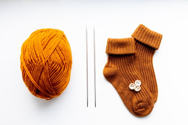 Foto set voor het breien van kinderkousen oranje draden breien naalden knopen centimeter