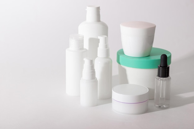 Set of white cosmetic bottles and jars with hard shadows Home and beauty salon care concept