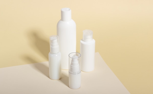 Set of white cosmetic bottles and jars with hard shadows. Home and beauty salon care concept